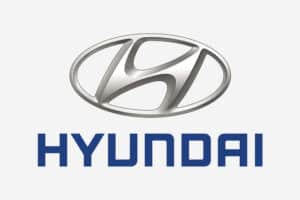 Hyundai logo. Silver, stylised 'H' in an oval, above the blue "HYUNDAI" text.