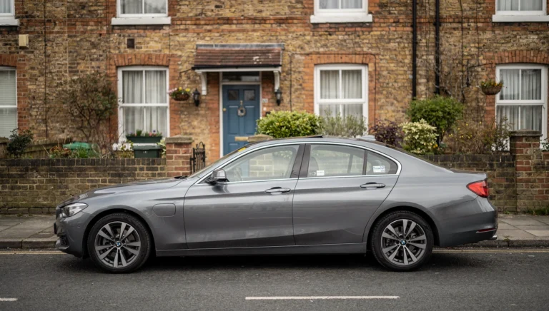 Private hire saloon parked outside a terraced home
